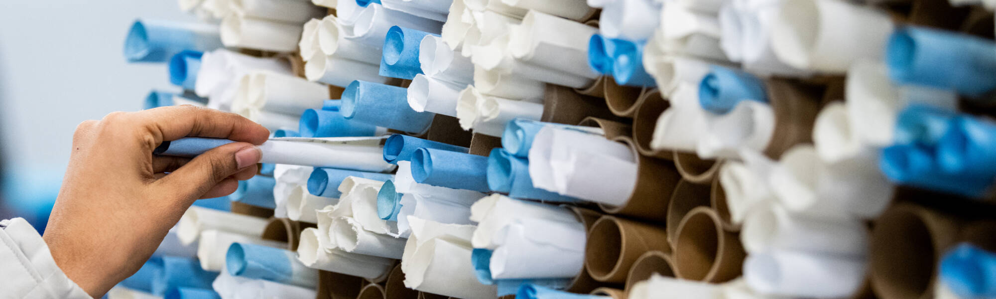 A student tucks a written note into the wishing wall at a booth hosted by the Kaufman Interfaith Institute during the Multicultural Night March 20. Students wrote hopes, prayers or wishes and rolled it up and added them to the wall.